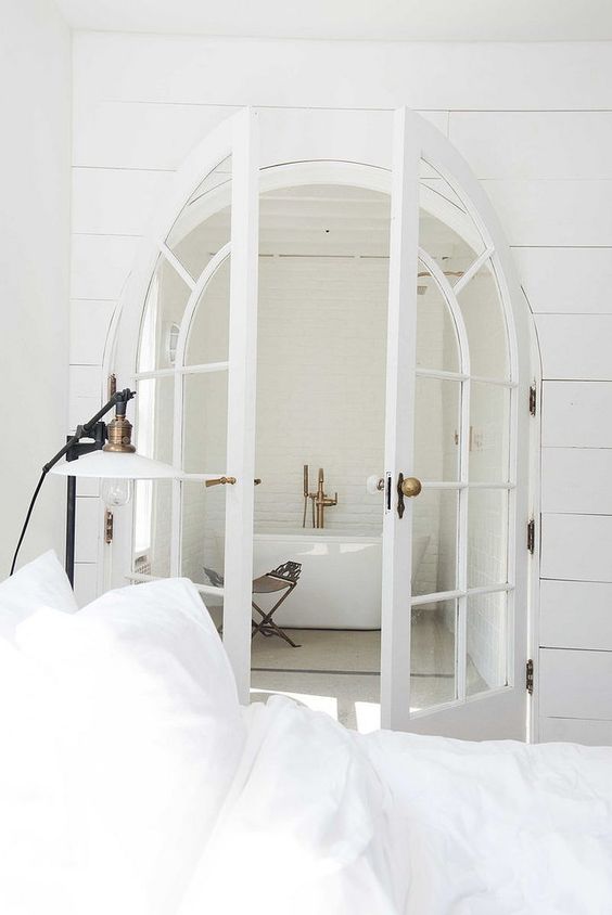 French arched doors leading to the bathroom make it more refined and chic at first glance
