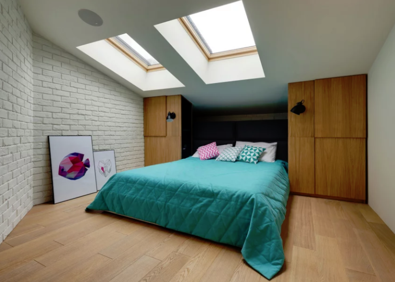 The second bedroom is smaller, it also features skylights, brick, storage units and a comfy bed
