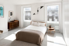 07 The bedroom features mid-century modern style, with comfy wooden furniture, bold artworks and a black metal lamp
