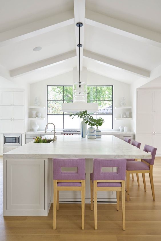 lilac upholstered stools add a touch of soft color to the neutral kitchen and make it cooler