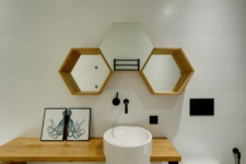 08 The powder room is done with hex mirrors, a sink on a wooden vanity