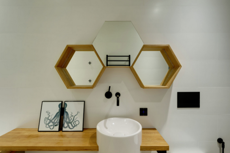 The powder room is done with hex mirrors, a sink on a wooden vanity