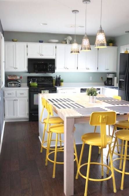 industrial and vintage bright yellow stools spruce up the neutral and blue kitchen and stand out a lot