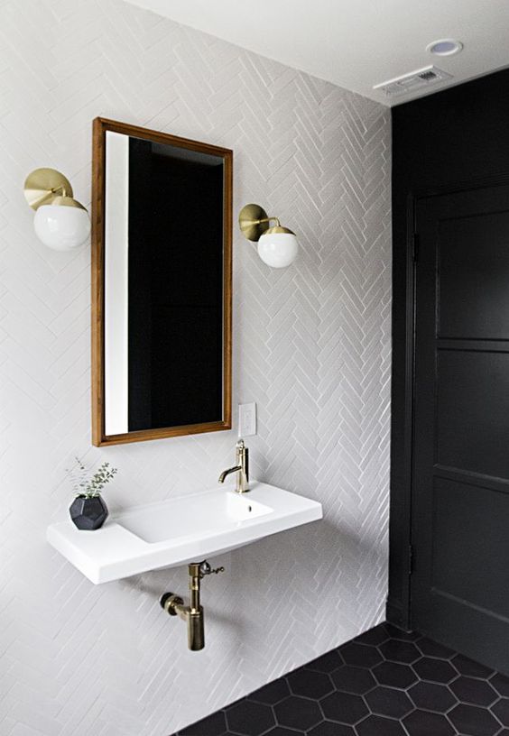 white skinny tiles in a  cheveron pattern paired with black hexagon tiles on the floor for a chic bathroom look