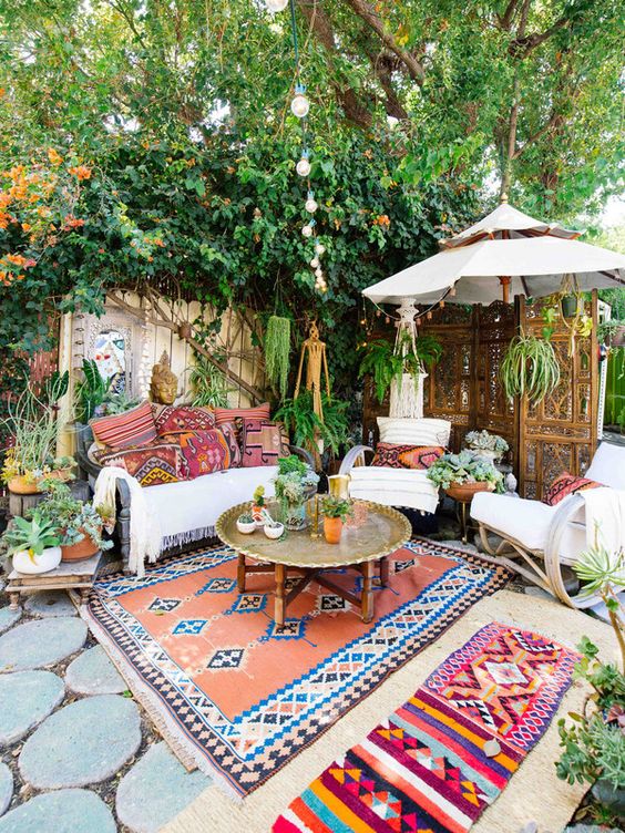 a colorful boho chic patio with a metal coffee table in the center and some seating furniture around it