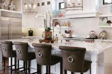 09 dark leather upholstered vintage inspired stools with ring pulls stand out in a neutral kitchen and add drama