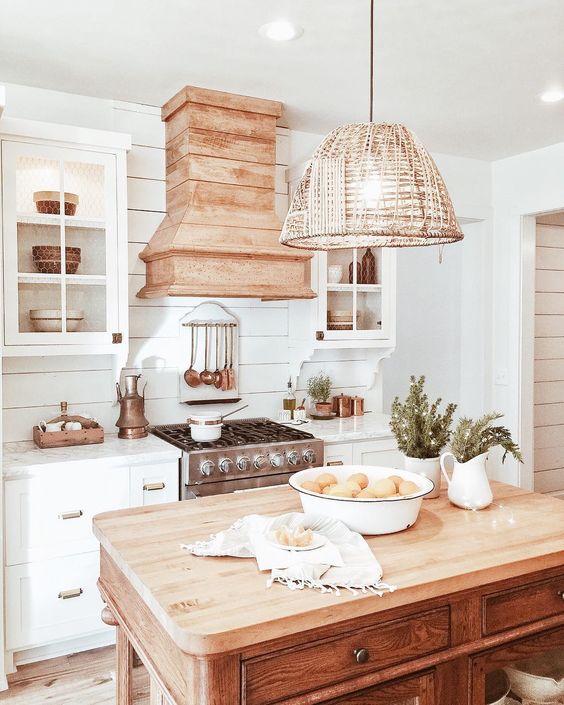 a vintage beach cottage kitchen with a wicker lampshade over the kitchen island for a more relaxed feel