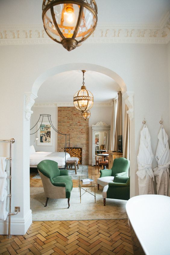 an arched doorway between the bedroom and bathroom highlights the refined style of the whole layout