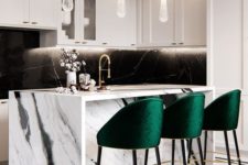 11 bold emerald stools with gold touches add color to the monochromatic kitchen and make the space cozier