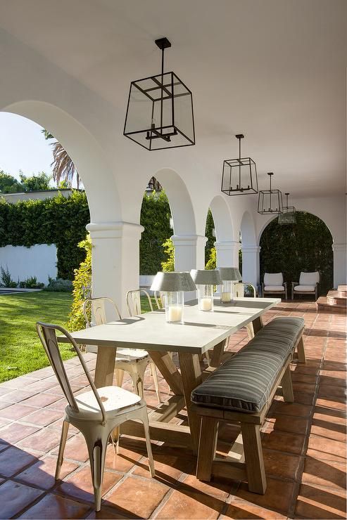a cozy terrace with arched doorways and some comfy furniture brings in that elegant Spanish colonial style