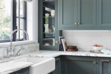 an elegant vintage green kitchen with skinny white tiles and marble countertops for a more refined and stylish look