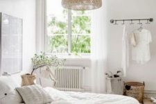 13 a welcoming neutral bedroom with a large wicker lamp over the bed that adds a natural feel to the space