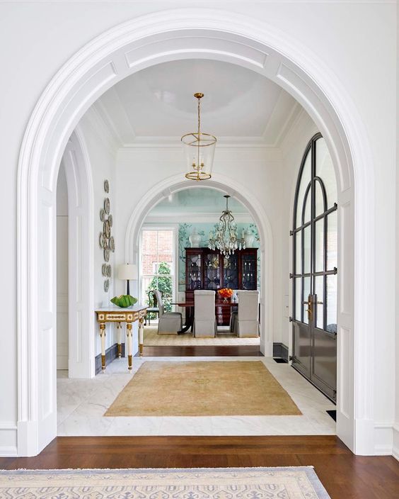 a very elegant and a bit formal entryway with arched doorways and arched doors for a refined look