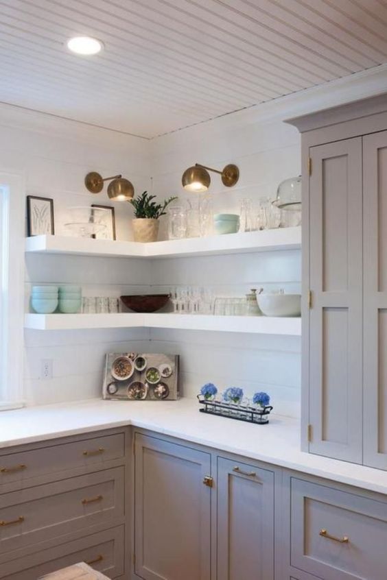 white thick corner shelves with additional spotlights are great to save some space in the kitchen