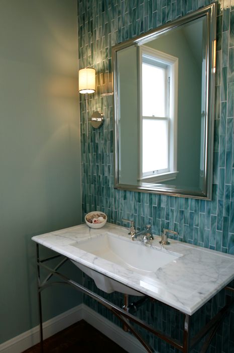 a chic vintage-inspired bathroom with mint green walls and a turquoise skinny tile wall plus a marble clad sink