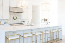 15 very elegant gold stools with white seats highlight the kitchen design and echo with the pendant lamps
