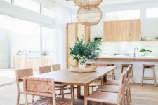 15 woven leather chairs, light-colored wood and roudn wicker lampshades over the dining space make it feel beachy