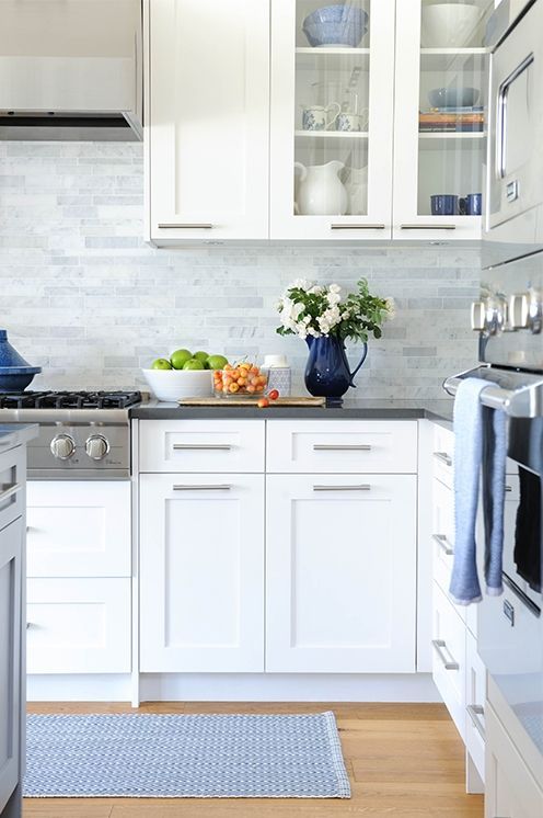 white modern cabinets, grey countertops and grey marble skinny tiles on the backsplash for a neutral and welcoming kitchen