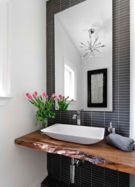 a contemporary bathroom with a navy skinny tile statement wall, a live edge floating vanity and a geometric sink