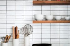 17 white skinny tiles accented with black grout highlight the contemporary style of the kitchen
