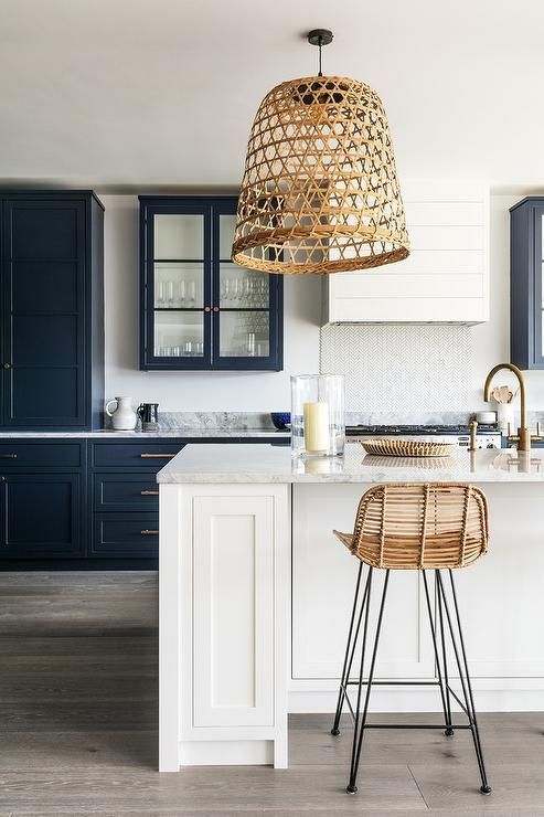 a crispy kitchen in black and white looks contrasting and bold and a wicker lampshade and a rattan chair add a relaxed feel
