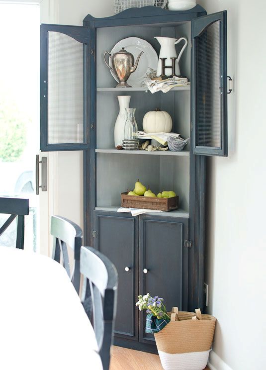 a graphite grey corner cabinet for storage and displaying any decorative objects