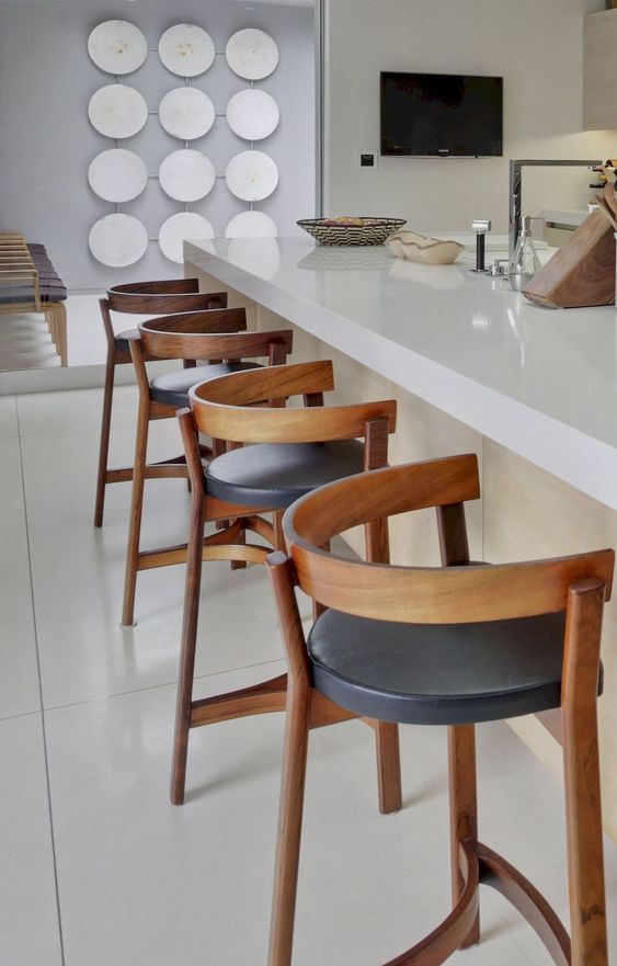 bold wood and leather stools spruce up a neutral space and add a bit of drama to the kitchen