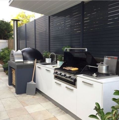 a contemporary outdoor kitchen with a grill and a pizza oven is a great idea for every patio