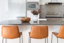 19 chic brown leather stools with black metal legs look very chic and add a textural touch to the space