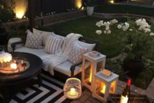 20 a cozy patio with a striped rug, candle lanterns and potted blooms that refresh the look