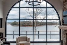 20 a living room with an oversized arched window that brings a gorgeous view inside