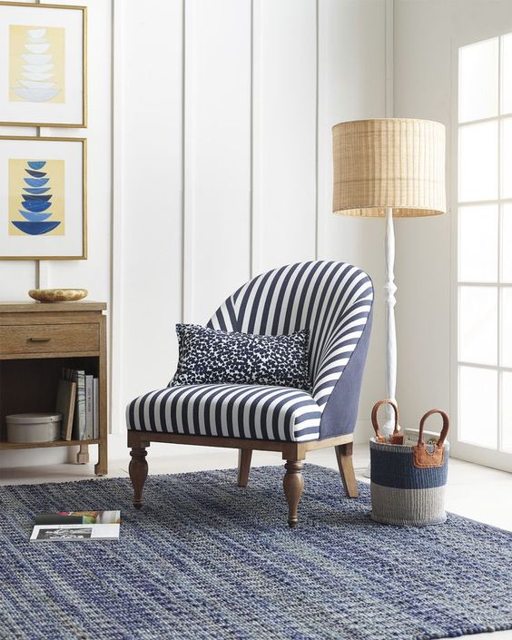 A nautical nook with a classic striped chair and a vintage inspired floor lamp with a wicker lampshade