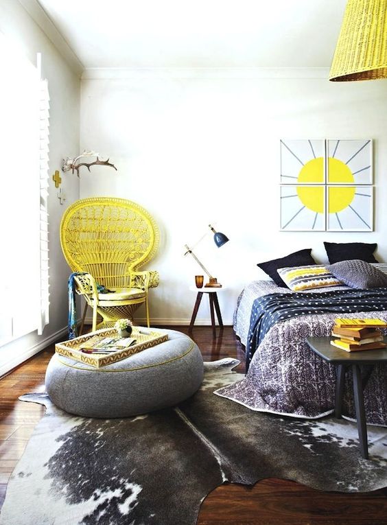 bright yellow touches including a peacock chair in the corner make this grey boho bedroom bold and sunshine-filled