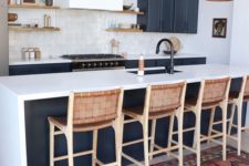 23 leather stools with wooden framing match the pendant lamps and refresh the monochromatic kitchen