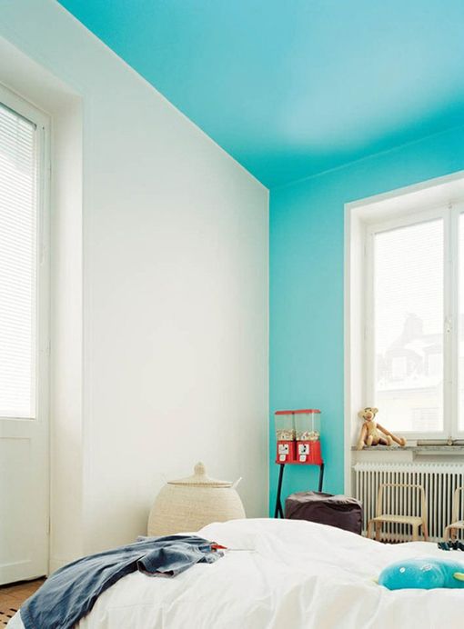a simple bedroom spruced up with a turquoise ceiling that comes down to the walls for a brighter touch