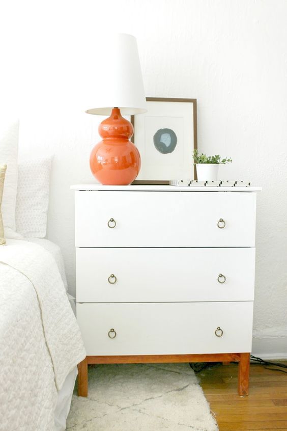 an IKEA Tarva dresser hack with white paint, stained legs and ring pulls provides much storage space