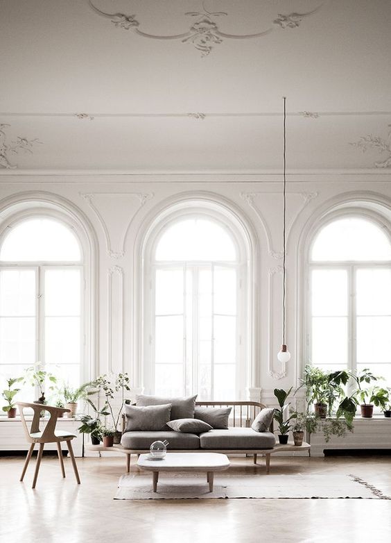 a contemporary living room featuring lots of arched windows with much light and coziness