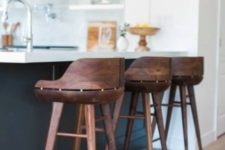 26 very eye-catchy dark stained wooden stools contrast the black and white kitchen island and look rich
