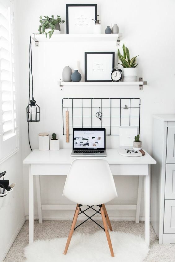 a Nordic home office nook done in white and accented with a black grid on the wall, a pendant lamp and chair elements