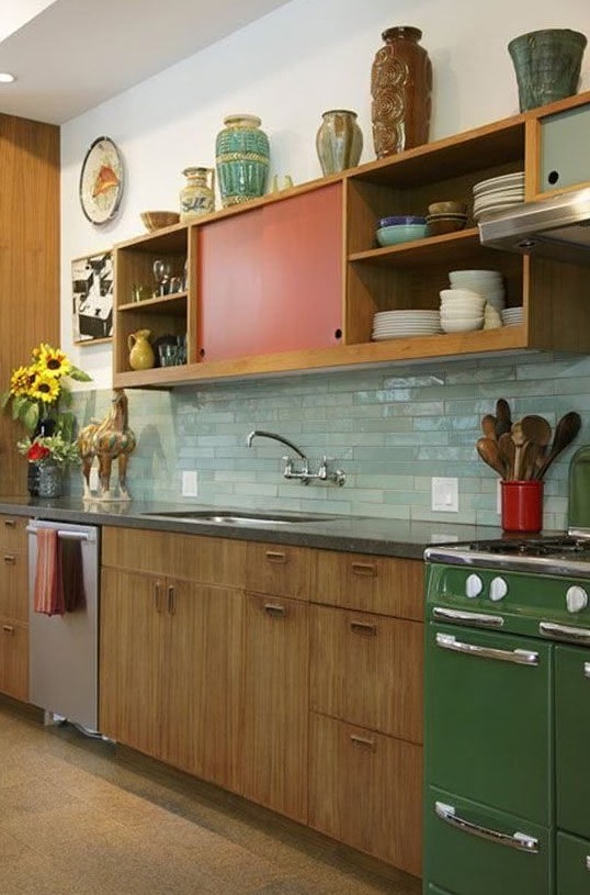 a bright mid-century modern kitchen with red and green touches and mint green skinny tiles on the backsplash