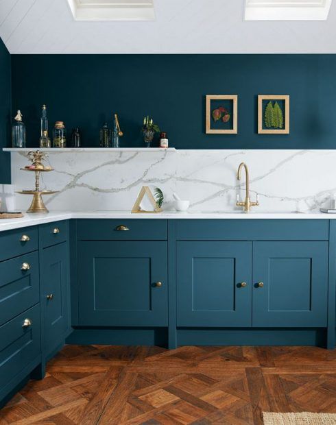 a chic and stylish teal kitchen with white stone countertops and a matchign backsplash plus gold touches