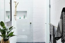 a chic contemporary bathroom with grey tiles on the floor and white skinny tiles on the walls plus niches