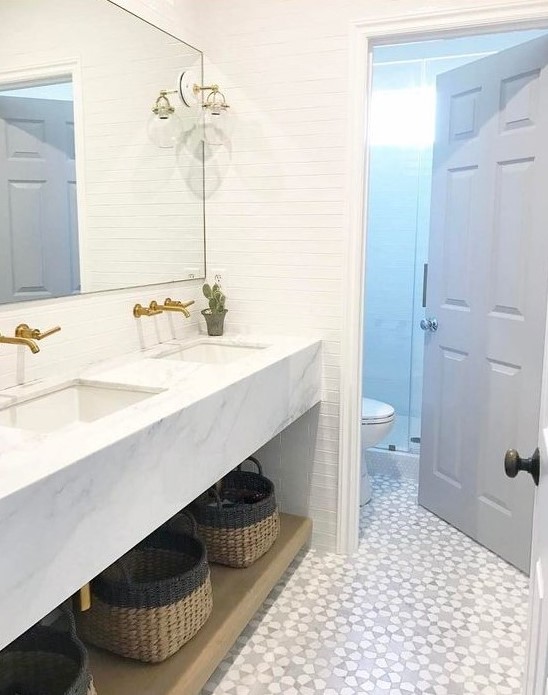 A chic modern farmhouse bathroom with white skinny tiles and a mosaic floor is a stylish space with an eye catchy touch