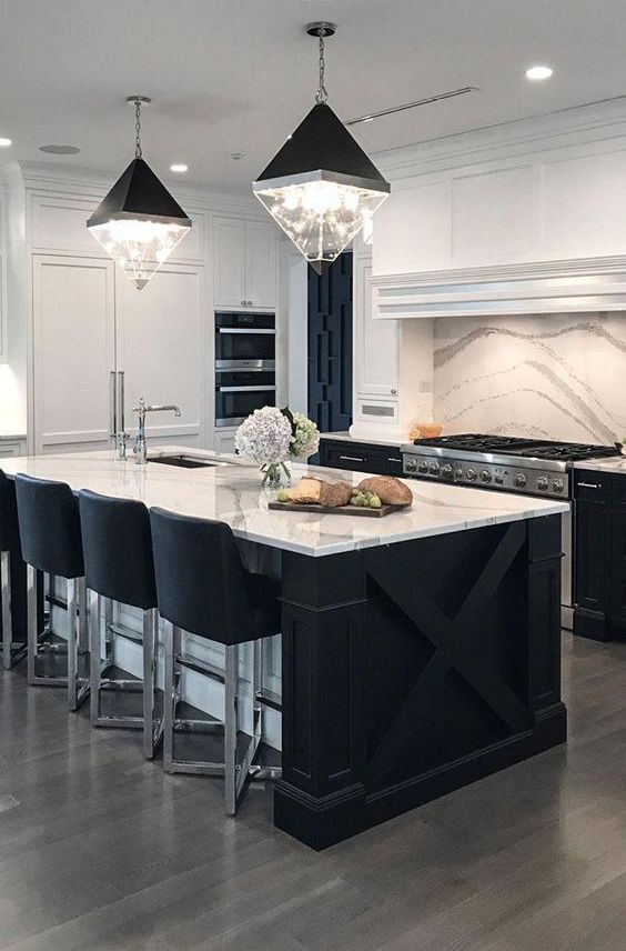 a contemporary kitchen with black cabinets, white stone countertops and a matching backsplash plus catchy lamps