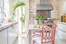 a creative tropical kitchen with flamingo wallpaper, sleek white cabinets, pink rattan chairs, tropical plants