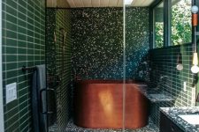 a green mid-century modern bathroom with terrazzo and skinny tiles, windows, a copper soak tub, a floating vanity