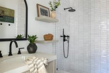 a mid-century modern bathroom with white stacked tiles, wooden beams, a ribbed vanity and black fixtures