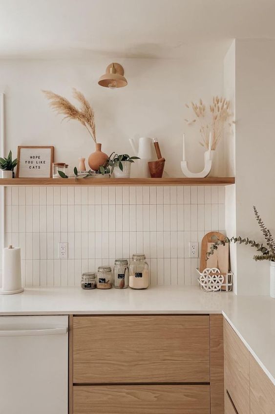 a modern boho kitchen with MEDF cabinetry, a white skinny tile backsplash and white countertops, an open shelf and decor