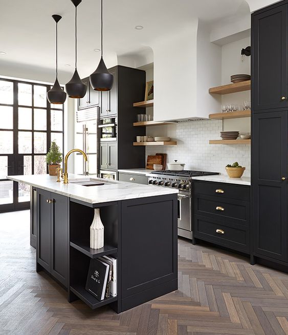 a modern farmhouse kitchen with black cabinets and white stone countertops plus brass hardware