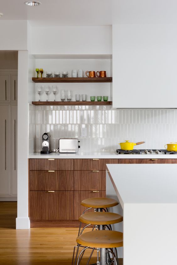 a modern kitchen with rich-stained cabinets, a white skiny tile backsplash, white countertops and open shelves plus a kitchen island